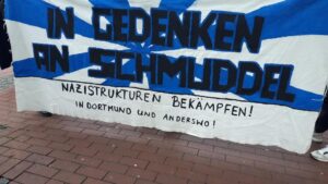 Transparent auf der Kundgebung mit der Aufschrift "In Gedenken an Schmuddel. Nazistrukturen Bekämpfen. In Dortmund und Anderswo"