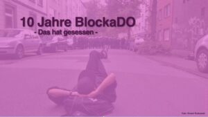 Lila eingetöntes Bild mit einem Menschen, der vor einer Polizeikette entspannt auf der Straße liegt, dazu der Text "10 Jahre BlockaDO - Das hat gesessen"