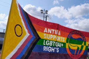 Hochbanner mit der Progressive-Pride Flagge und der Aufschrift Antifa Supports LGBTQAI+ rights